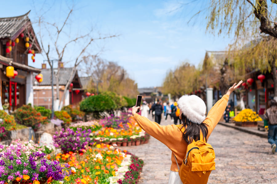 Mujer turista en una zona habitacional de Lijiang